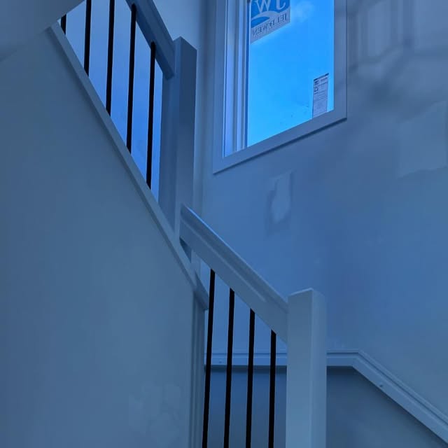 White stair handrail with black metal balusters installed by Nand Finishing