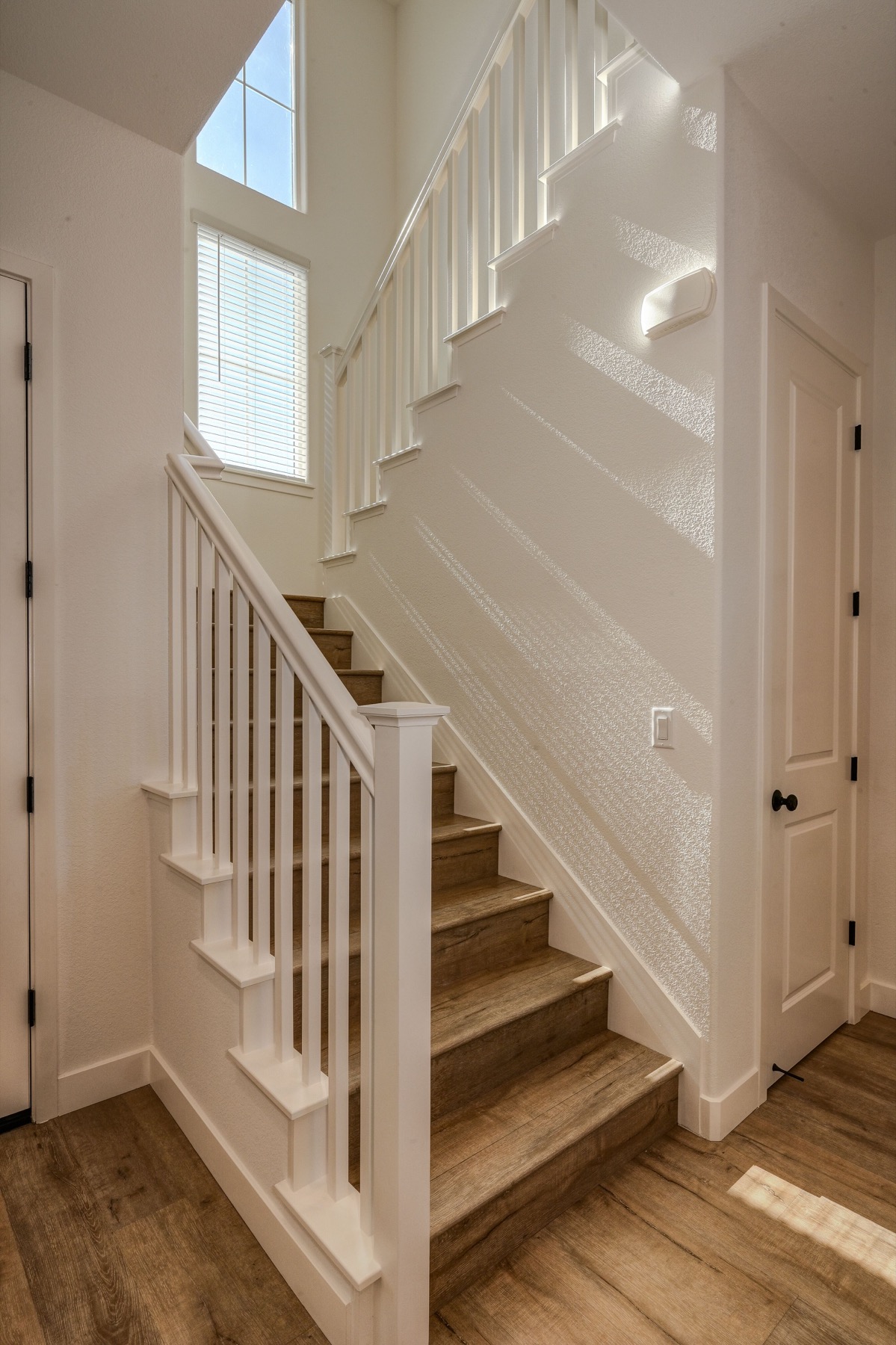 Wood staircase with finished handrail, newel post, and interior door trim